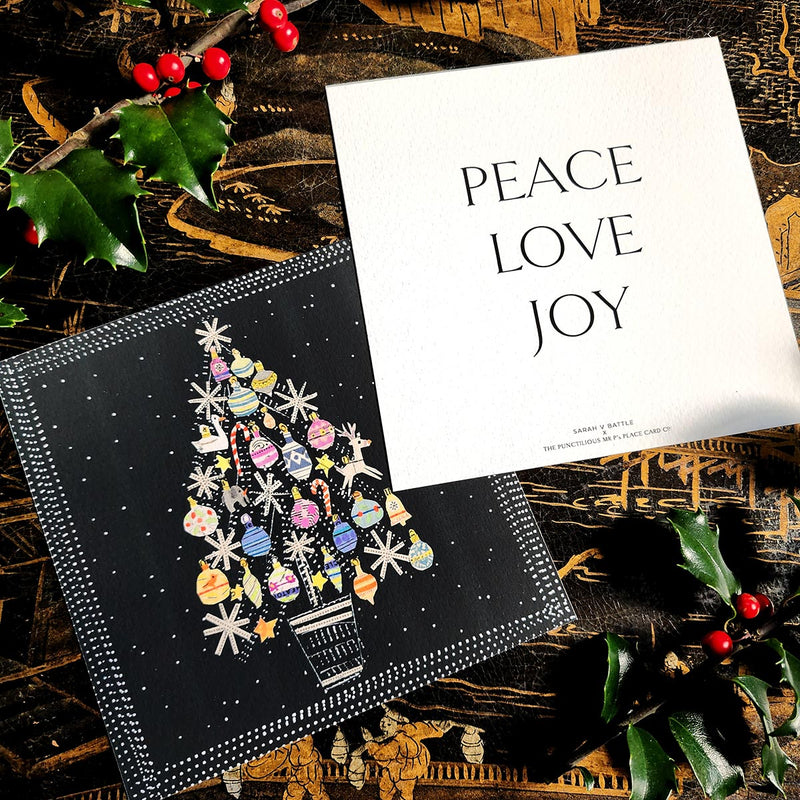 The Punctilious Mr. p's place card co. collab with sarah v battle showing the christmas tree and back of holiday card that reads: peace, love, joy