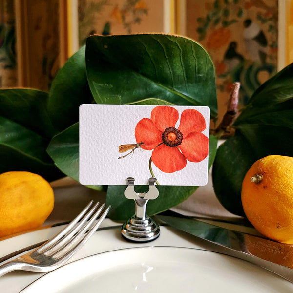 The Punctilious mr. P's Pace Card Co. "Blossoms" custom place card on a silver place card holder with magnolia leaves and lemons in the background against a chinoiserie screen
