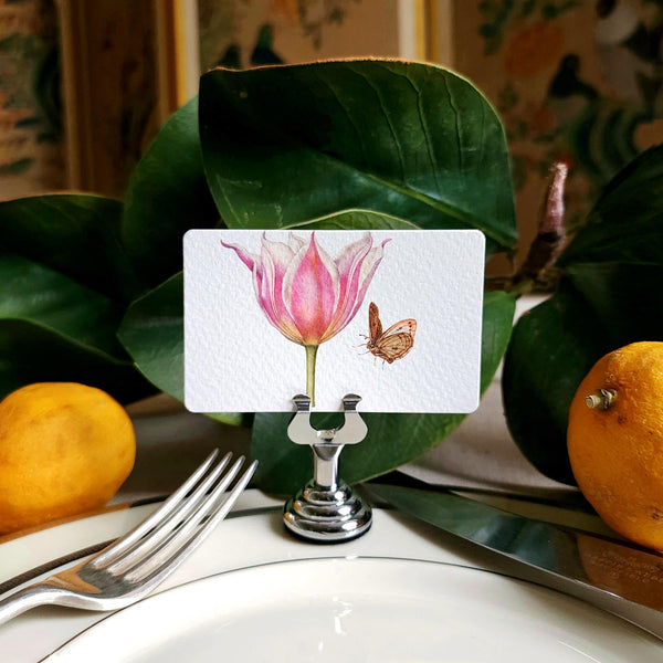 The Punctilious mr. P's Pace Card Co. "Blossoms" custom place card on a silver place card holder with magnolia leaves and lemons in the background against a chinoiserie screen