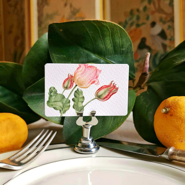 The Punctilious mr. P's Pace Card Co. "Parrot Tulips" custom place card on a silver place card holder with magnolia leaves and lemons in the background against a chinoiserie screen
