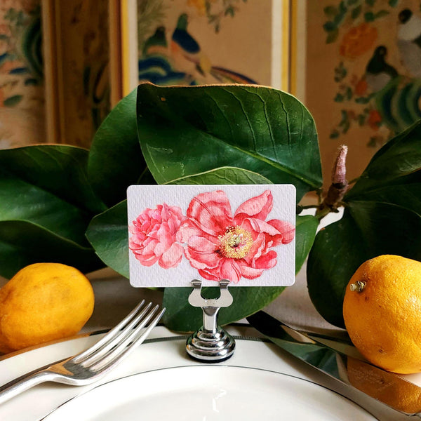 The Punctilious mr. P's Pace Card Co. "Peony" custom place card on a silver place card holder with magnolia leaves and lemons in the background against a chinoiserie screen