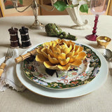 video of Yellow ceramic peony flower on a decorative plate with floral patterns on a simple tablescape