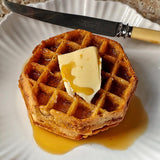 golden brown waffles drizzled with The Punctilious Mr. P's Pantry speakeasy bourbon maple syrup