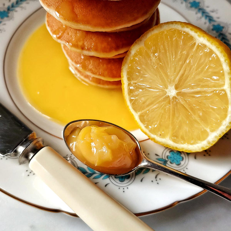 a stack of pancakes with Mr. P's Pantry lemon curd drizzled on top