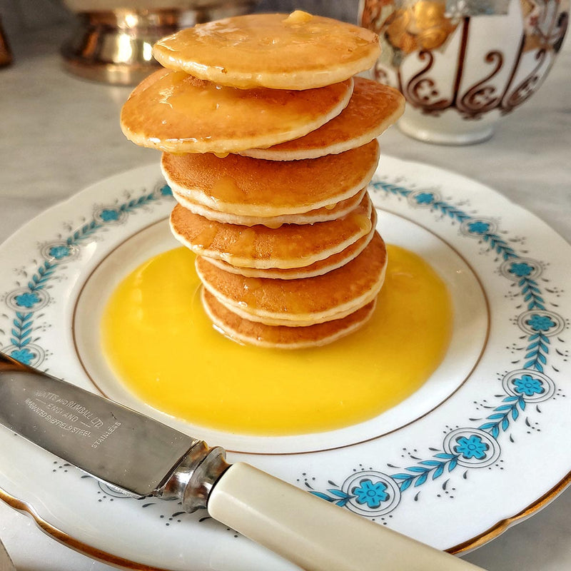 a stack of pancakes with Mr. P's Pantry lemon curd drizzled on top