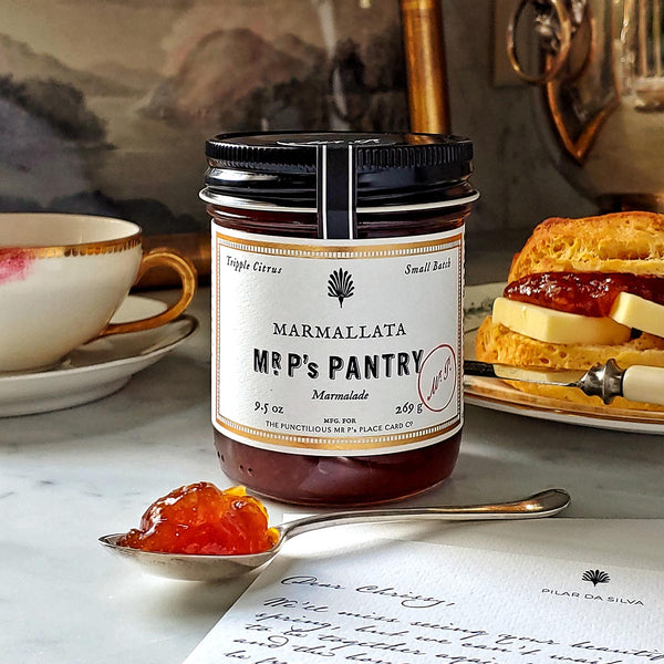 a jar Mr. P's Pantry marmalade on a marble tabletop with a porcelain tea cup and saucer