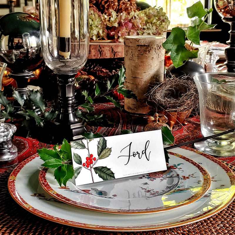 The Punctilious Mr. P's Place Card Co. 'holly' custom laydown place card on top of chinoiserie dinner plate christmas tablescape with candles and fine decoration