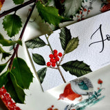 detail of The Punctilious Mr. P's Place Card Co. 'Holly' custom laydown place card on top of chinoiserie dinner plate