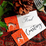 both The Punctilious Mr. P's Place Card Co. 'Reindeer games' laydown custom place cards on top of paisley tablecloth