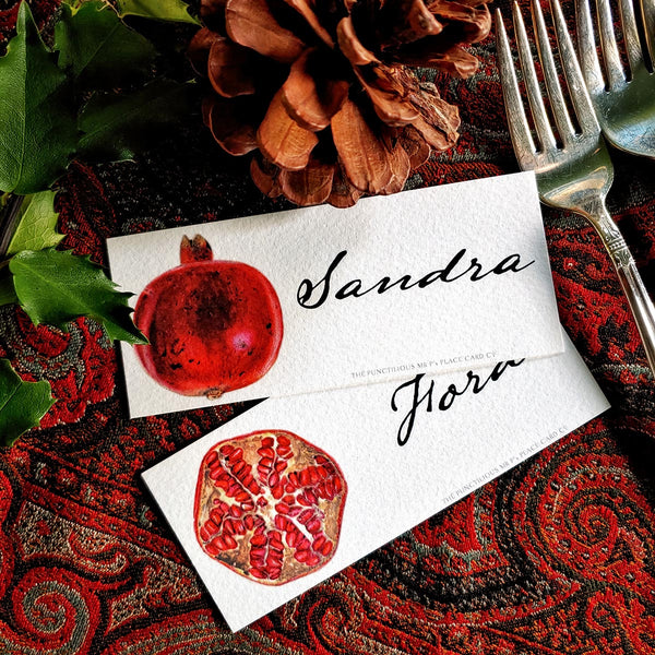 both The Punctilious Mr. P's Place Card Co. 'Pomegranate' laydown custom place cards on top of paisley tablecloth
