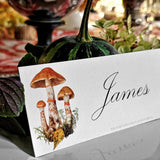 The Punctilious Mr. P's Place Card Co. 'Red Bands Mushroom' laydown custom place card on top of linen napkin with bamboo cutlery and a red color blocked tablecloth