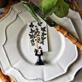 The Punctilious Mr. P's Place Card Co. 'Ivy' custom place card  resting on white china with bamboo cutlery and live potted ivy in the background