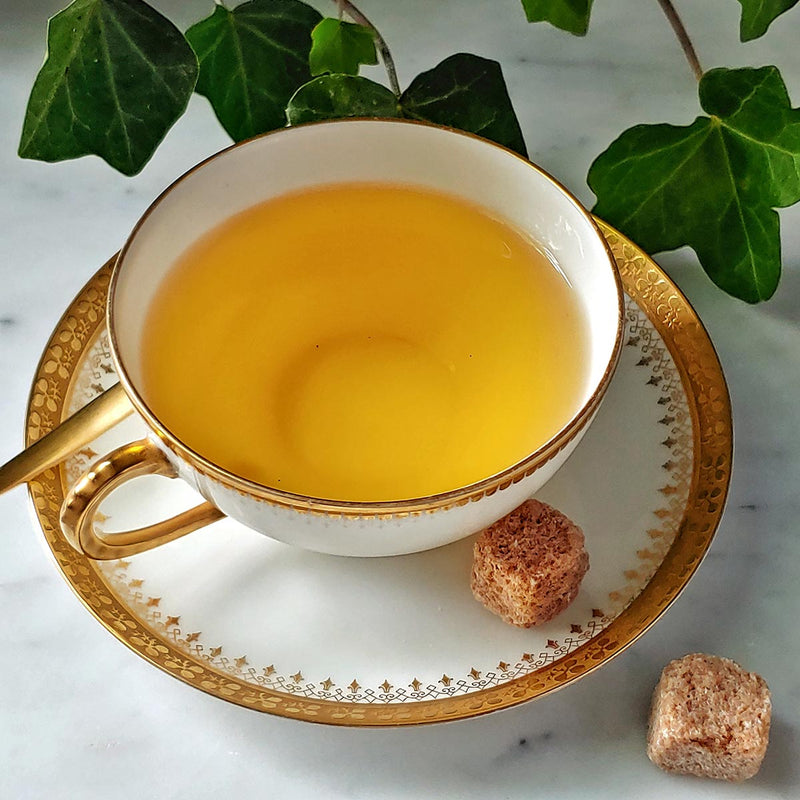 The Punctilious Mr. P's Jasmine flavored green Tea in a fine tea cup and saucer