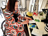 Marian McEvoy writing note cards at her desk, wearing a beautiful and colorful 1960s inspired floral dress