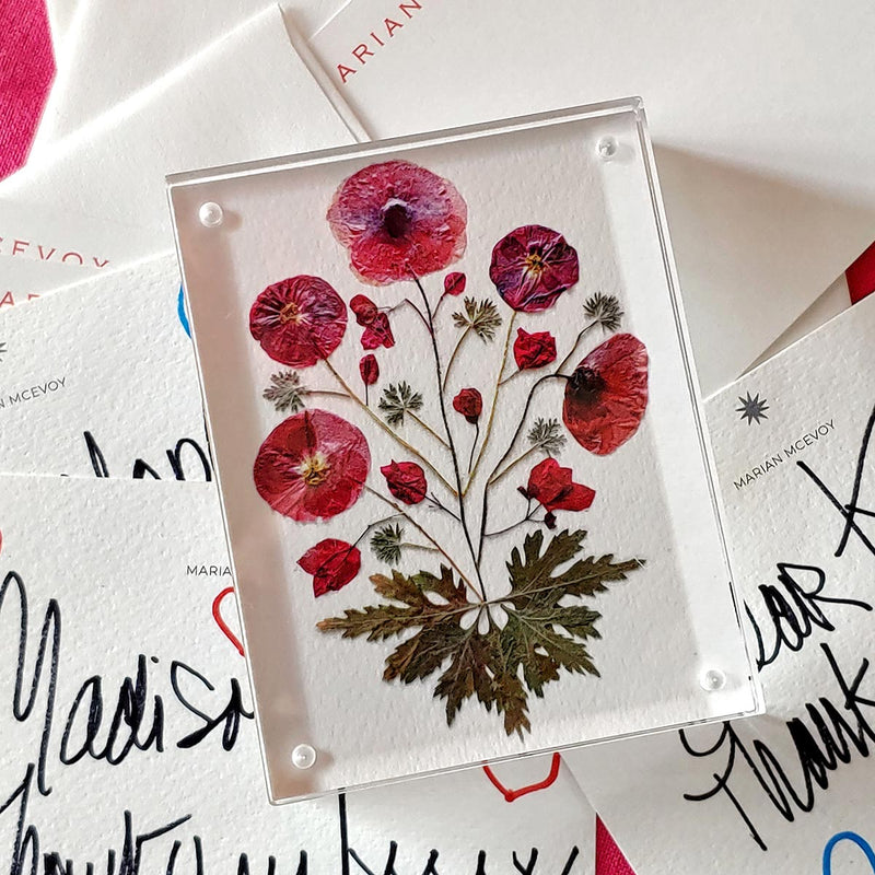 Marian McEvoy x The Punctilious Mr. P's Place Card Co collab with close up of red pressed poppy botanical motif magnetic acrylic paperweight