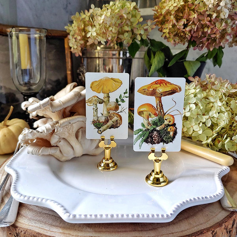 The Punctilious Mr. P's Place Card Co. Saffron Parasol Mushrooms custom place cards on a  tabletop with fine china, hydrangea and white pumpkins