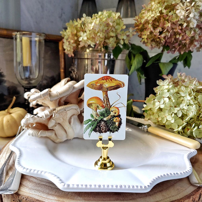 The Punctilious Mr. P's Place Card Co. Saffron Parasol Mushrooms custom place cards on a  tabletop with fine china, hydrangea and white pumpkins