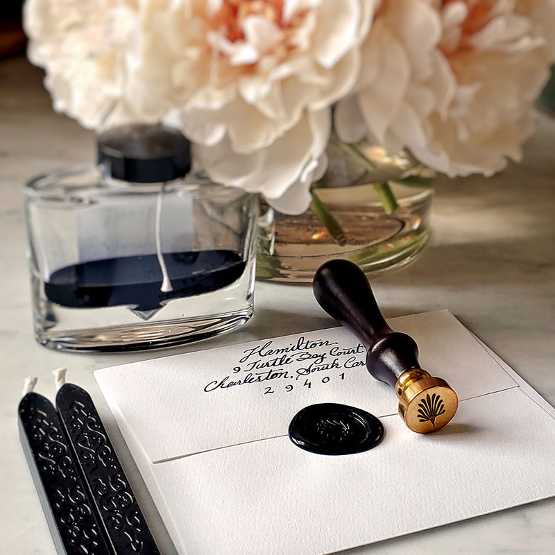 The Punctilious Mr. P's Place Card Co. anthemion wax seal with 2 black wax sticks, ink bottle and beautiful vase of peony flowers