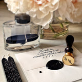 The Punctilious Mr. P's Place Card Co. signature wax seal with 2 black wax sticks, ink bottle and beautiful vase of peony flowers